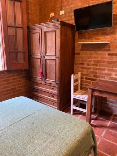 a bedroom with a bed and a dresser and a desk at La Ribera Aparts in Santa Rosa de Calamuchita