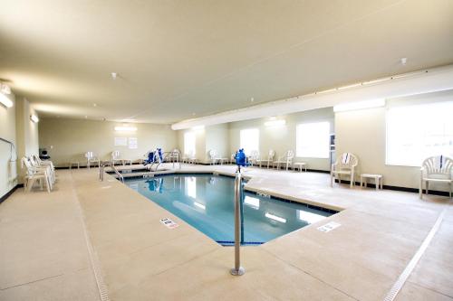 a large pool in a room with chairs and tables at Cobblestone Hotel & Suites - Devils Lake in Devils Lake