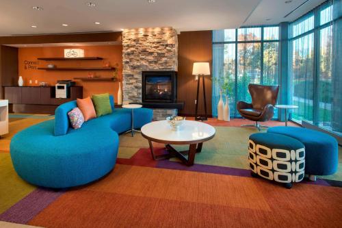 a living room with blue furniture and a fireplace at Fairfield Inn & Suites by Marriott Syracuse Carrier Circle in East Syracuse