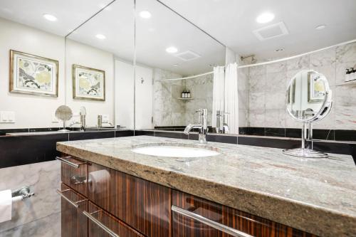 a bathroom with a sink and a large mirror at Seashore On The Sand in Carlsbad