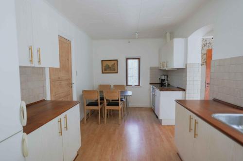 a kitchen with white cabinets and a table in it at Bright Modern Holiday Home Near Hindemae in Ullerslev