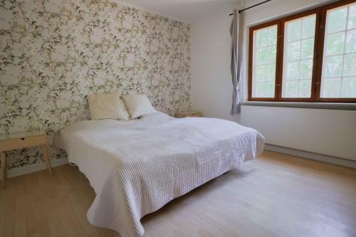 a bedroom with a white bed and a window at Bright Modern Holiday Home Near Hindemae in Ullerslev
