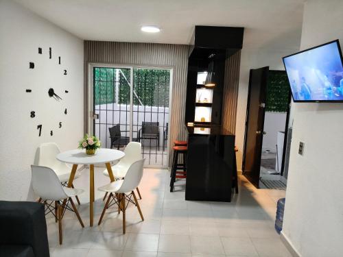 ein Wohnzimmer mit einem Tisch und weißen Stühlen in der Unterkunft Residencial 2 ríos in Dos Ríos