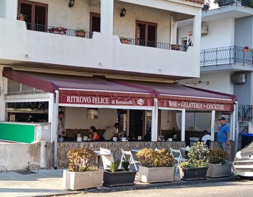 un restaurant avec des plantes devant un bâtiment dans l'établissement Exclusive BB Villa Rosa, à Messina