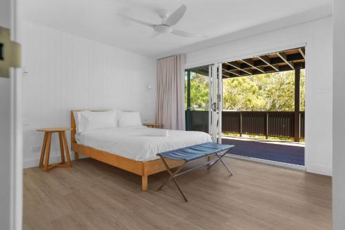 a bedroom with a bed and a large window at Luna Beach House, Vincentia in Vincentia