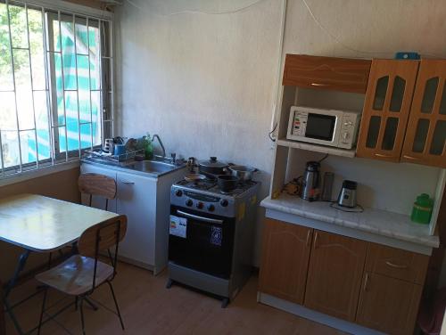 una piccola cucina con piano cottura e forno a microonde di Alojamiento Viña del mar Casa Segundo piso entero a Viña del Mar