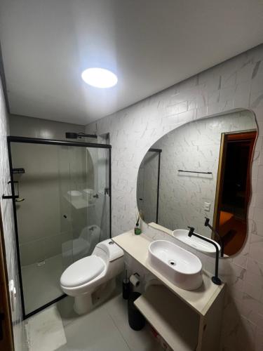 a bathroom with a toilet and a sink and a shower at Enseada Beach in São Sebastião
