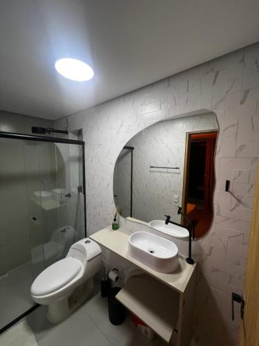 bagno con 2 lavandini, doccia e specchio di Enseada Beach a São Sebastião