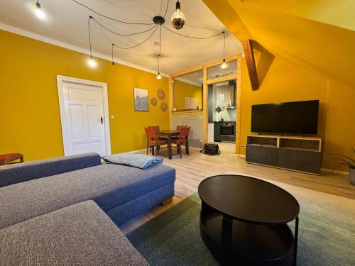 ein Wohnzimmer mit einer blauen Couch und einem Fernseher in der Unterkunft Altstadt Quartier in Bad Freienwalde
