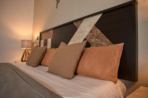 a bedroom with a large bed with brown pillows at Casa almendros 31 in Ciudad Guzmán