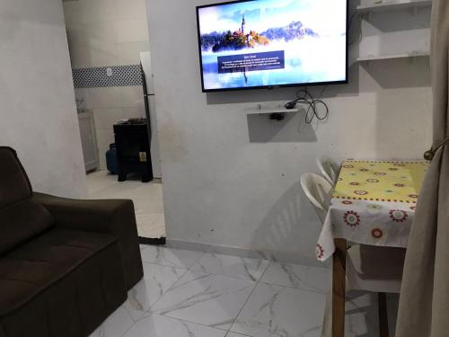 un soggiorno con una TV a parete di Casa Magalhães a Morro de São Paulo