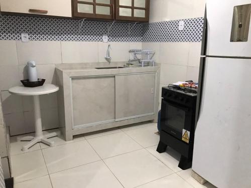 una cucina con frigorifero, lavandino e tavolo di Casa Magalhães a Morro de São Paulo