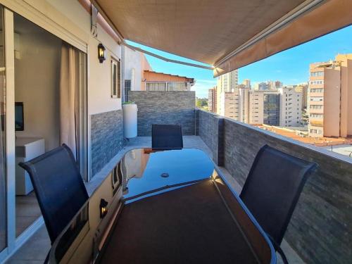 a balcony with two chairs and a table on a balcony at Apartalux Ático Jaime I in Benidorm