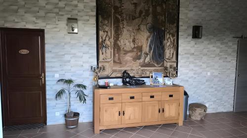 Un armario de madera en una habitación con una planta en maceta. en Chambres D'hôtes Histoire D'anges, en Joursac