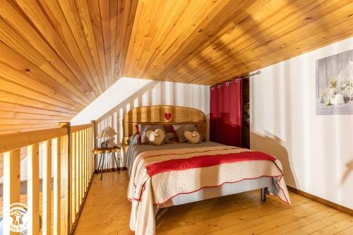 Un dormitorio con una cama con techo de madera. en Chambres D'hôtes Histoire D'anges, en Joursac