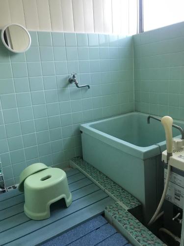 a bathroom with a tub and a toilet in it at YabFarm Lodge 102 in Kashiwa