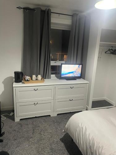 a bedroom with a white dresser with a laptop on it at Bridgewater Court 2 in Southampton