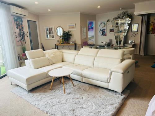 a living room with a white couch and a table at Nelson Apartment, Relaxing, Hobart Escape in Sandy Bay