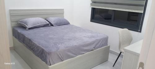 a bed with two pillows and a window in a room at غزو 15 in Aydūn