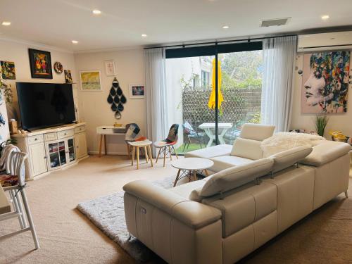 a living room with a couch and a tv at Nelson Apartment, Relaxing, Hobart Escape in Sandy Bay