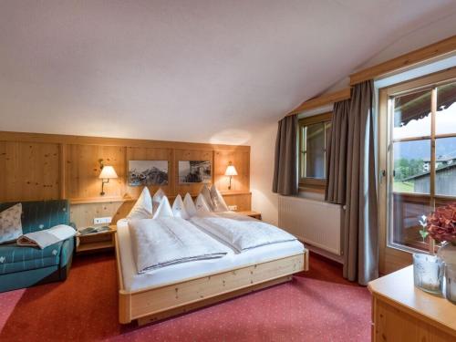 Un dormitorio con una cama grande y un sofá. en Sonnblick in Huaterhof, en Laimach