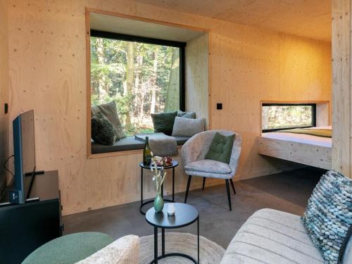 Holiday cottage in Teteringen with Wi-Fi في Teteringen: غرفة بها أريكة وسرير ونافذة