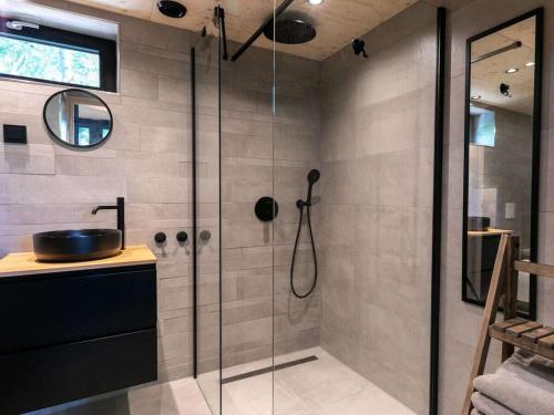 Holiday cottage in Teteringen with Wi-Fi في Teteringen: حمام مع دش زجاجي مع حوض