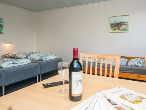 4 person holiday home in Højer في Højer: زجاجة من النبيذ موضوعة على طاولة مع كوب