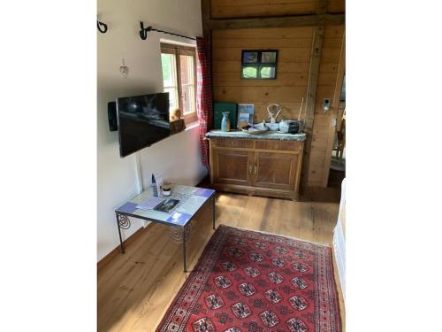 a living room with a table and a sink at Rustico Maiensäss Pütschai in Sta Maria Val Müstair