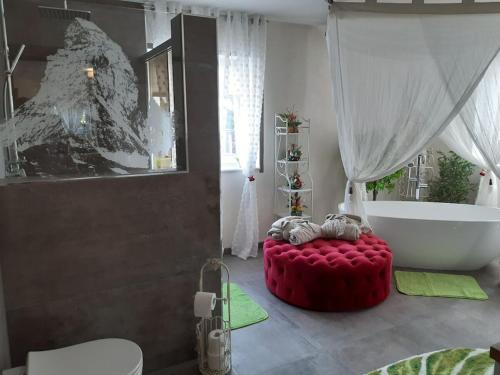 AltershausenSteigerwald Resort的带浴缸和红色脚凳的浴室