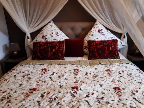 AltershausenSteigerwald Resort的一张带红白毯子和枕头的床