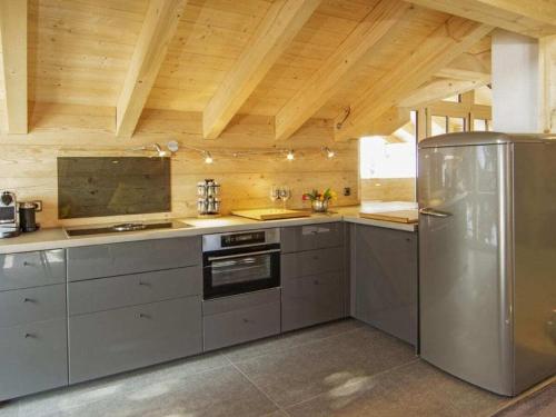 a kitchen with stainless steel appliances and wooden ceilings at Holiday apartment with 1 bedroom in Sigiswang