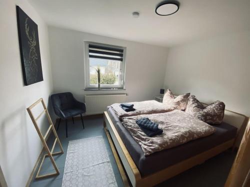 LangenhennersdorfHoliday home at the rock labyrinth的一间卧室，里面有一张床、一把椅子和一扇窗户