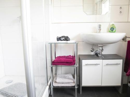 莫斯Holiday apartment in Moos with Wi-Fi的浴室设有水槽和带毛巾的架子。