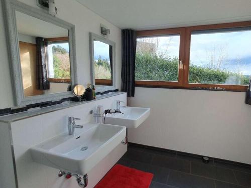 ein Badezimmer mit zwei Waschbecken und zwei Fenstern in der Unterkunft holiday apartment in Backenreute