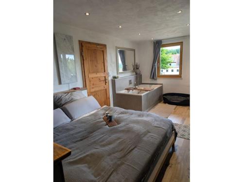ein Schlafzimmer mit einem Bett, einer Badewanne und einem Waschbecken in der Unterkunft Holiday home Talblick 13 in Burgwallbach