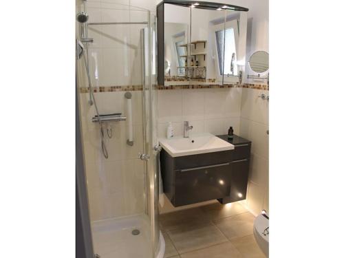 Un baño con ducha, lavabo y espejo. en Holiday home Heide, en Bad Bodenteich