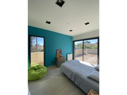 ein Schlafzimmer mit einem Bett und einer blauen Wand in der Unterkunft Villa Romia Villa Romia in Fréjus