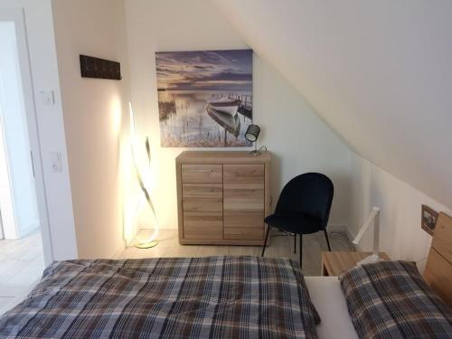 Un dormitorio con una cama, un escritorio y una silla. en Hannes' thatched house on Rügen, en Mellnitz