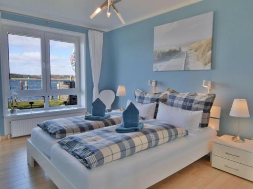 ein Schlafzimmer mit zwei Betten und einem großen Fenster in der Unterkunft Holiday apartment with 1 bedroom in Maasholm