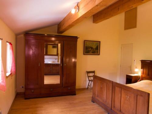 a bedroom with a bed and a wooden cabinet at Syrah - Domaine La Flotte in Chalabre