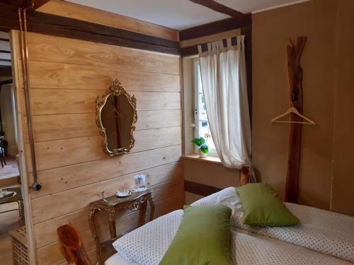 ein Schlafzimmer mit einer Holzwand mit einem Bett und einem Spiegel in der Unterkunft Chalet Bösleben in Bösleben-Wüllersleben