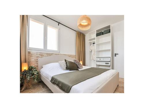 een slaapkamer met een groot wit bed en een raam bij Maison Laurier Rose in Plan-de-la-Tour