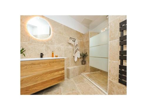 een badkamer met een bad en een wastafel bij Maison Laurier Rose in Plan-de-la-Tour