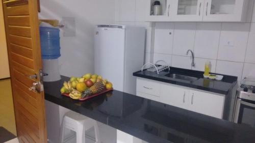 una cocina con un bol de fruta en una barra en Estúdio Ibiza II en Maceió