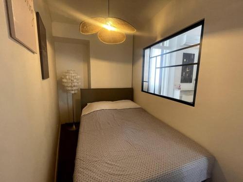 ein kleines Schlafzimmer mit einem Bett und einem Fenster in der Unterkunft Le Cannet apartmment for 4 Guests in Tanneron