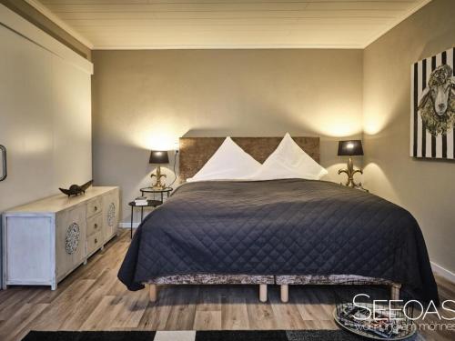 a bedroom with a large bed and two lamps at Holiday apartment with 1 bedroom in Südrandweg