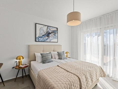 a white bedroom with a bed and a window at Villa in minj with swimming pool in Žminj