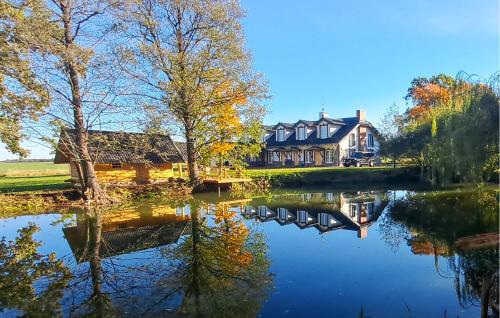 a house with a pond in front of it at Lovely Home In Srokowo With Sauna in Srokowo