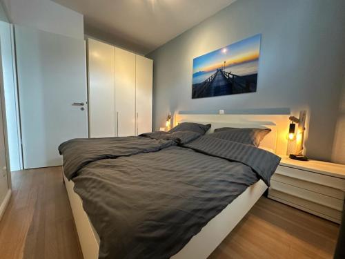 una camera da letto con un letto grande con un dipinto sul muro di Villa Marin, Apartment 6 a Zinnowitz